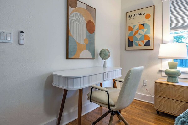 A room with a white desk, a chair, a globe, and two framed artworks. - 5th Avenue Bungalow by Velo (Tucson)