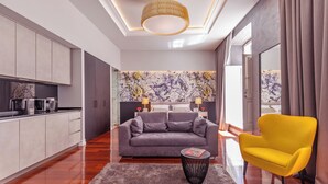 Una sala moderna con un sofá gris, un sillón amarillo y una mesita de centro.