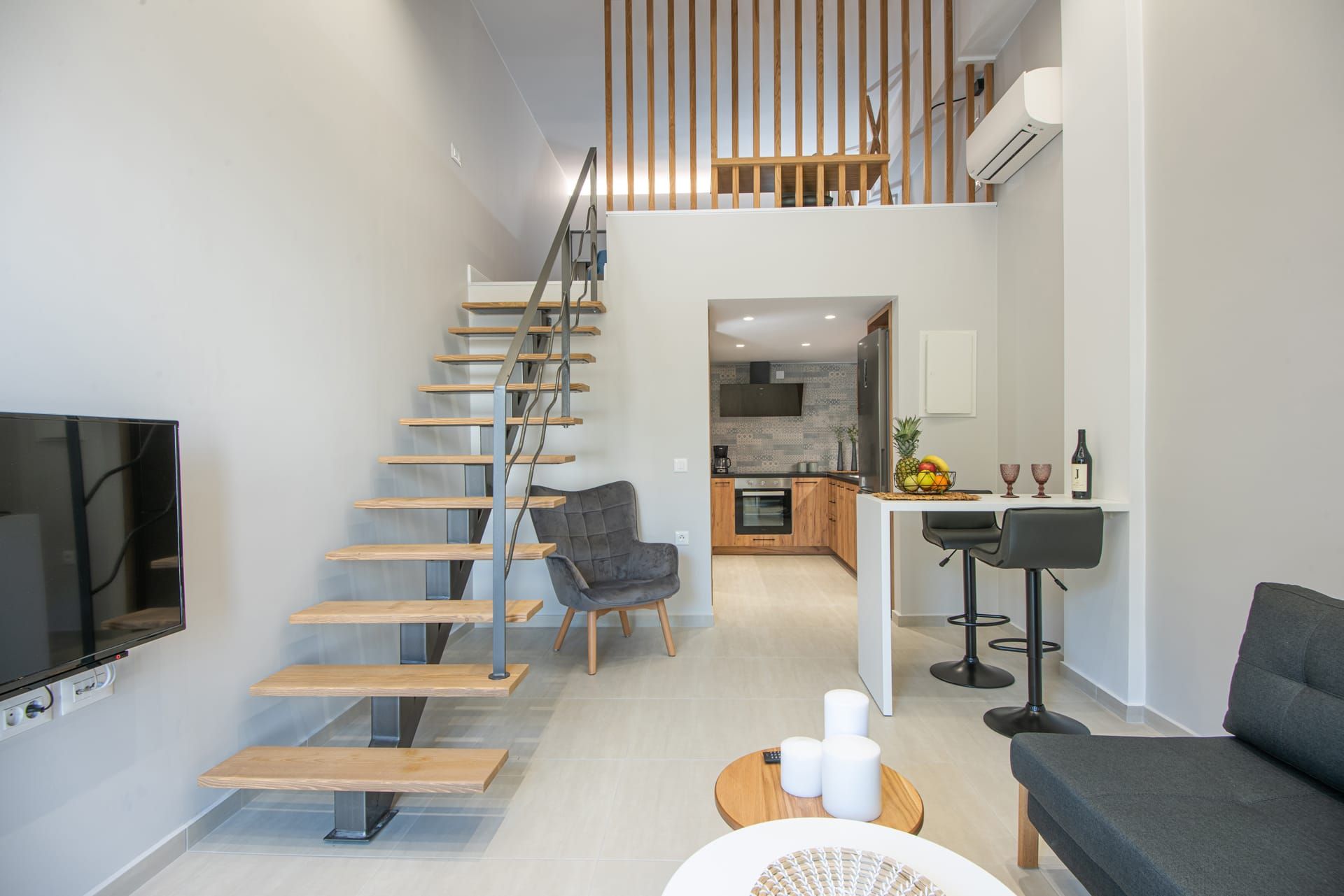 Un interior moderno con una escalera, una cocina, un comedor y una sala de estar.