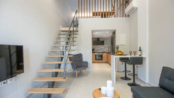 A modern interior with a staircase, a kitchen, a dining area, and a living room.