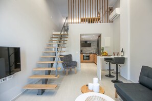 A modern interior with a staircase, a kitchen, a dining area, and a living room.