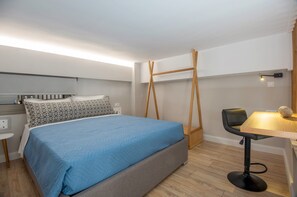 Una camera da letto moderna con un letto, una scrivania e una sedia.