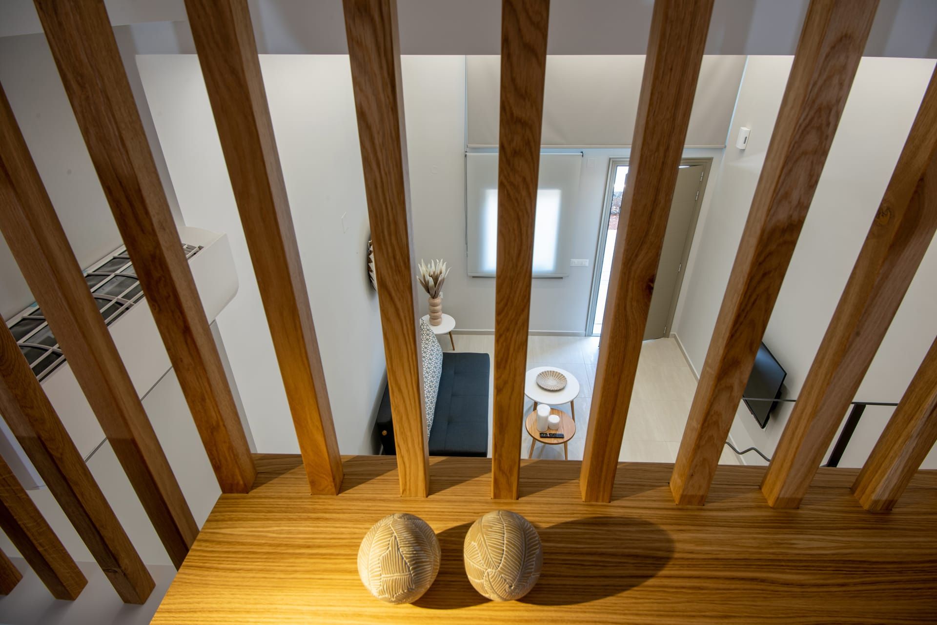 Una escalera de madera con dos objetos esféricos en el rellano.
