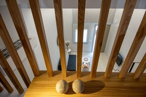 A wooden staircase with two spherical objects on the landing.