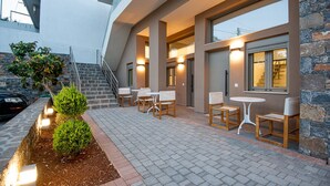Un espace extérieur moderne aménagé avec un mur en pierre, un escalier et une voiture garée à proximité.
