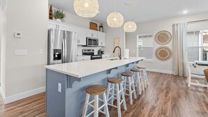 A modern kitchen with a central island, stainless steel appliances, and pendant lighting. - Gorgeous Lake View! Indoor Pool! 5 Min to Branson Strip! (Branson)