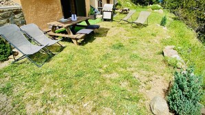 A patio area with a wooden table and chairs, a barbecue grill, and a large umbrella. - Cozy chalet with jacuzzi and lake views (Les Angles)