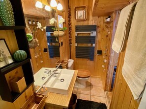 A compact wooden bathroom with a sink, toilet, and a small mirror. - Cozy chalet with jacuzzi and lake views (Les Angles)