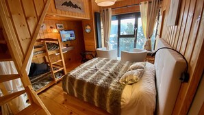A cozy wooden cabin bedroom with a bed, a desk, and a computer. - Cozy chalet with jacuzzi and lake views (Les Angles)