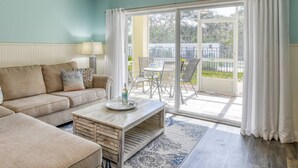 Un salon comprenant un canapé, une table basse et un coin repas avec des chaises et une table.