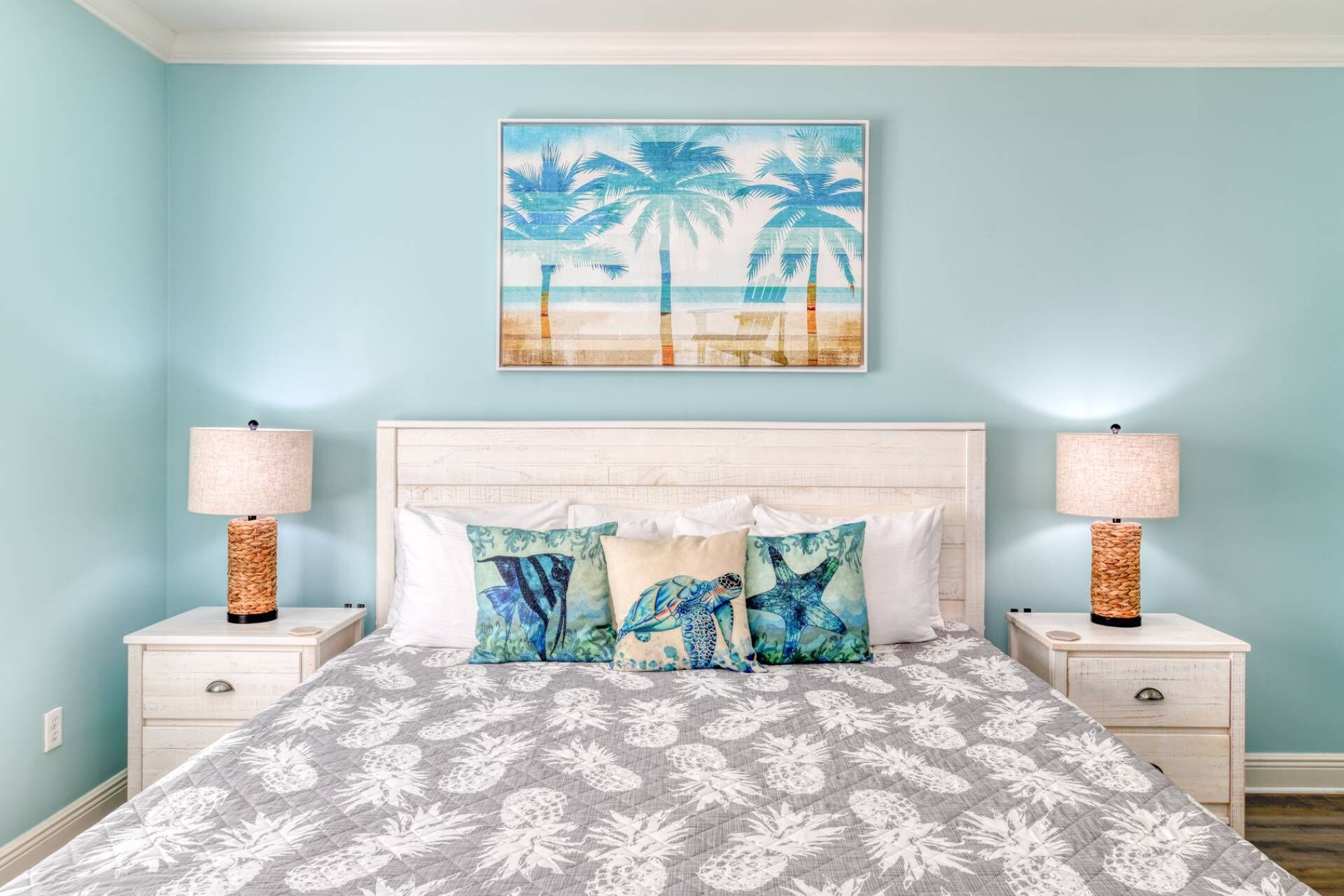 A bedroom with a bed, two nightstands, a headboard, and a wall painting.