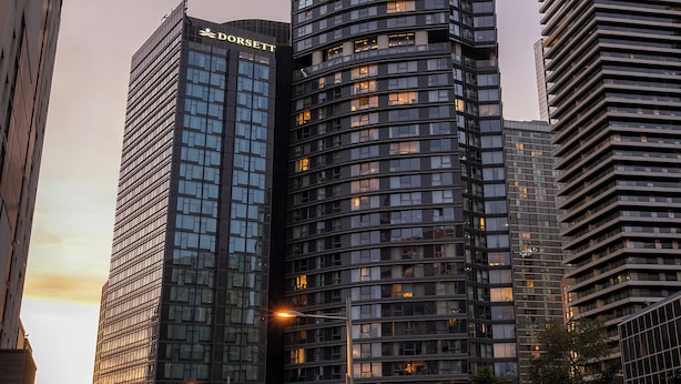 A modern high-rise building with a distinctive curved facade and a visible 'DORSETT' sign.