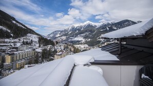 A snow-covered mountain landscape with buildings in the foreground and a clear sky. - Alpine ski Apartment Getaway (Bad Gastein)