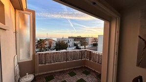 Un balcón con vista a edificios y un cielo despejado.