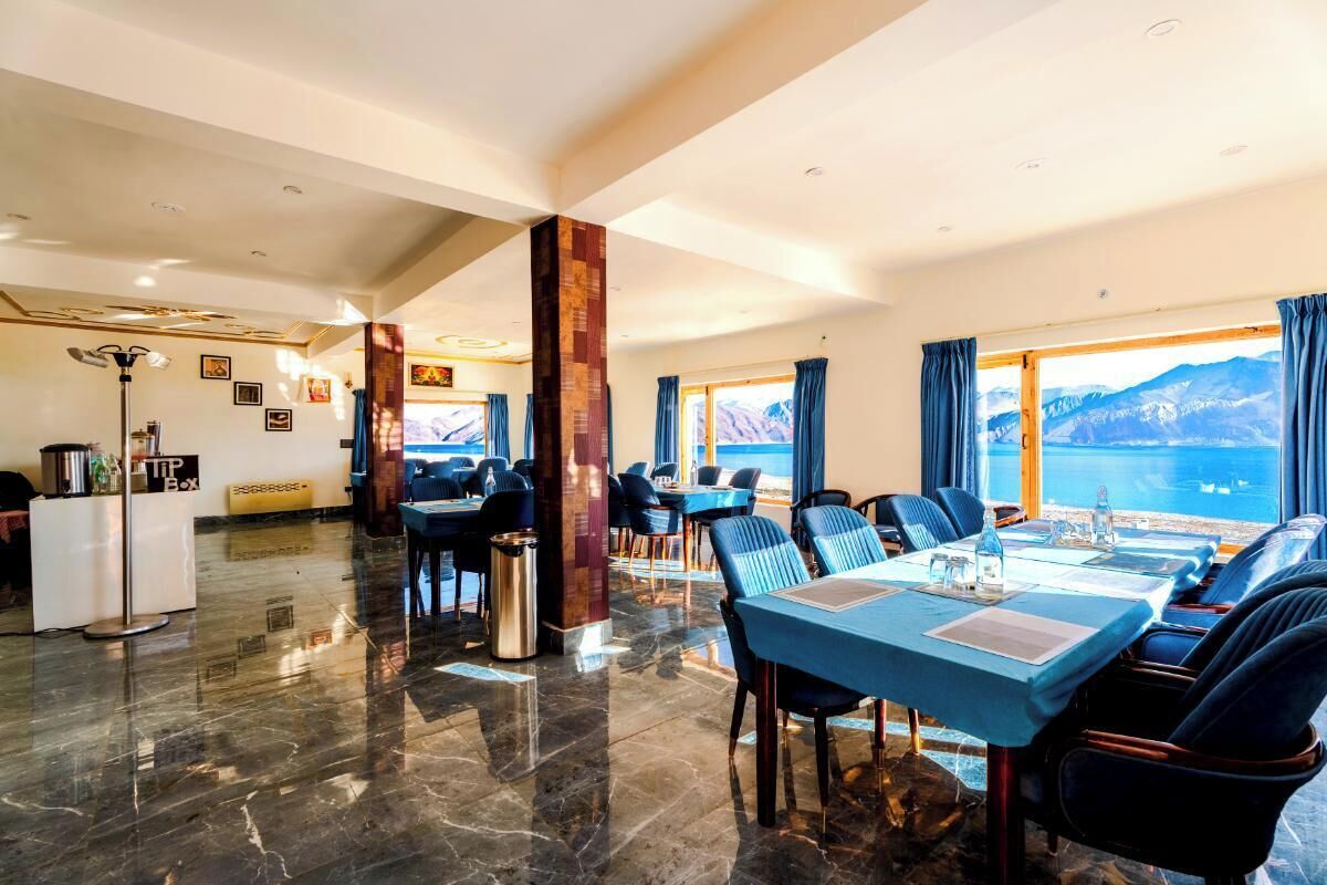A dining area with a large table, chairs, and a view of the sea.