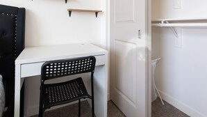 A room with a white desk, a black chair, and a white wardrobe with shelves. - Santa Ana Delightful 4 Bedroom House (Santa Ana)
