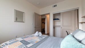 A bedroom with a bed, a mirror, and a door leading to a bathroom. - Santa Ana Delightful 4 Bedroom House (Santa Ana)