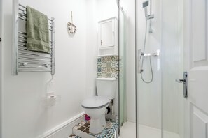 A bathroom with a toilet, a shower, and a glass-enclosed shower stall. - Spacious 3-Bedroom House in Vibrant Liverpool – Your Perfect Getaway (Liverpool)