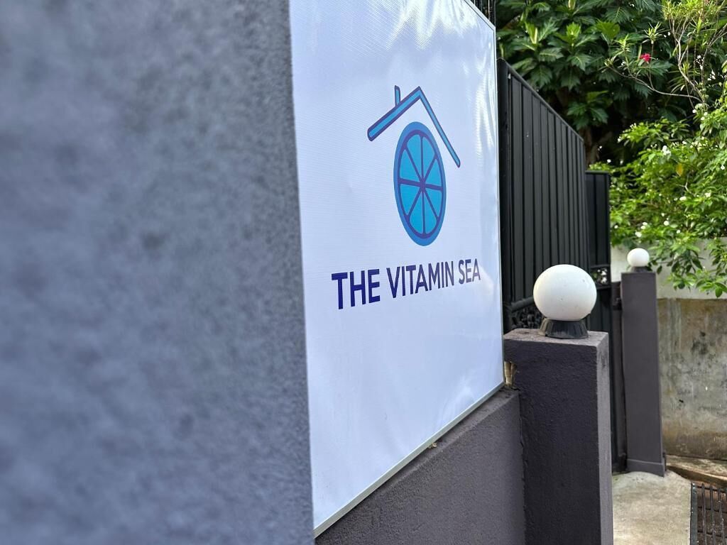 Ein Schild für "The Vitamin Sea" mit einem Logo, das ein Haus und eine Scheibe zeigt.