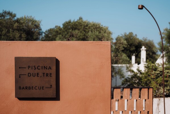 A sign with directions to 'Piscina, Due, Tre, Barbecue'. - OZIO - il trullo rosso (Fasano)