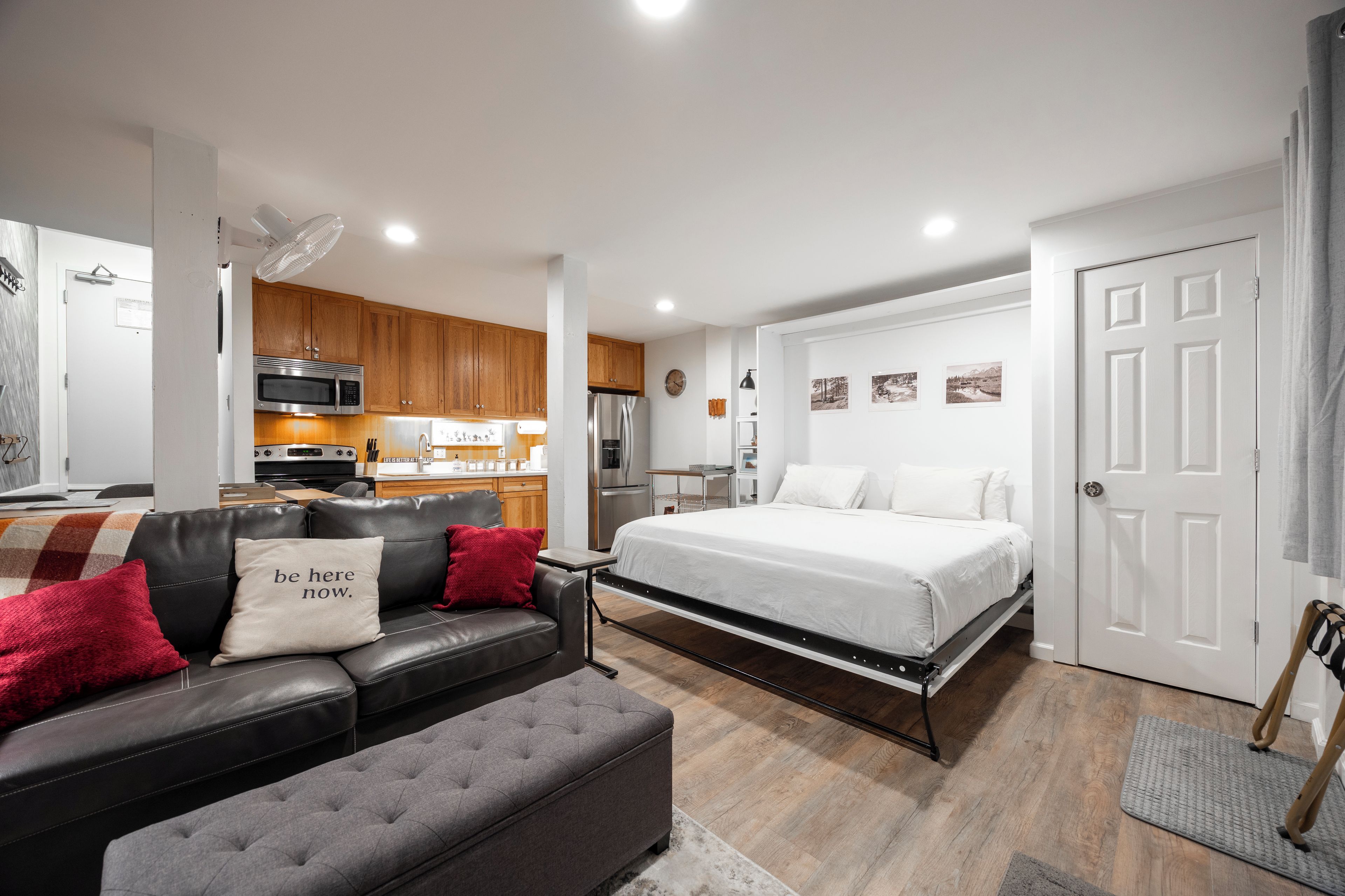 Um espaço compacto com cozinha compacta, cama, sofá e área de refeições.