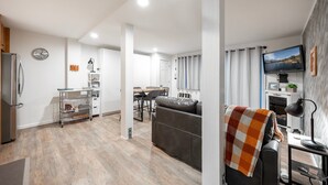 A modern living room with a sofa, a TV, and a fireplace. - Stunning Deluxe King Studio  #124 at Donner Lake Village (Truckee)
