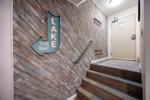 A staircase with a wooden wall and a directional sign indicating 'LAKE THIS WAY'.