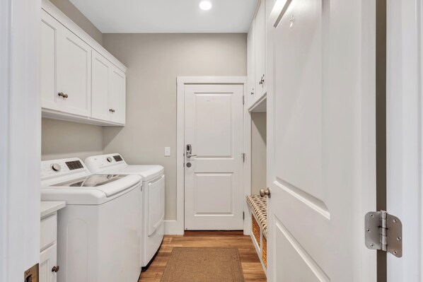 A laundry room with a white door, a washing machine, and a dryer.