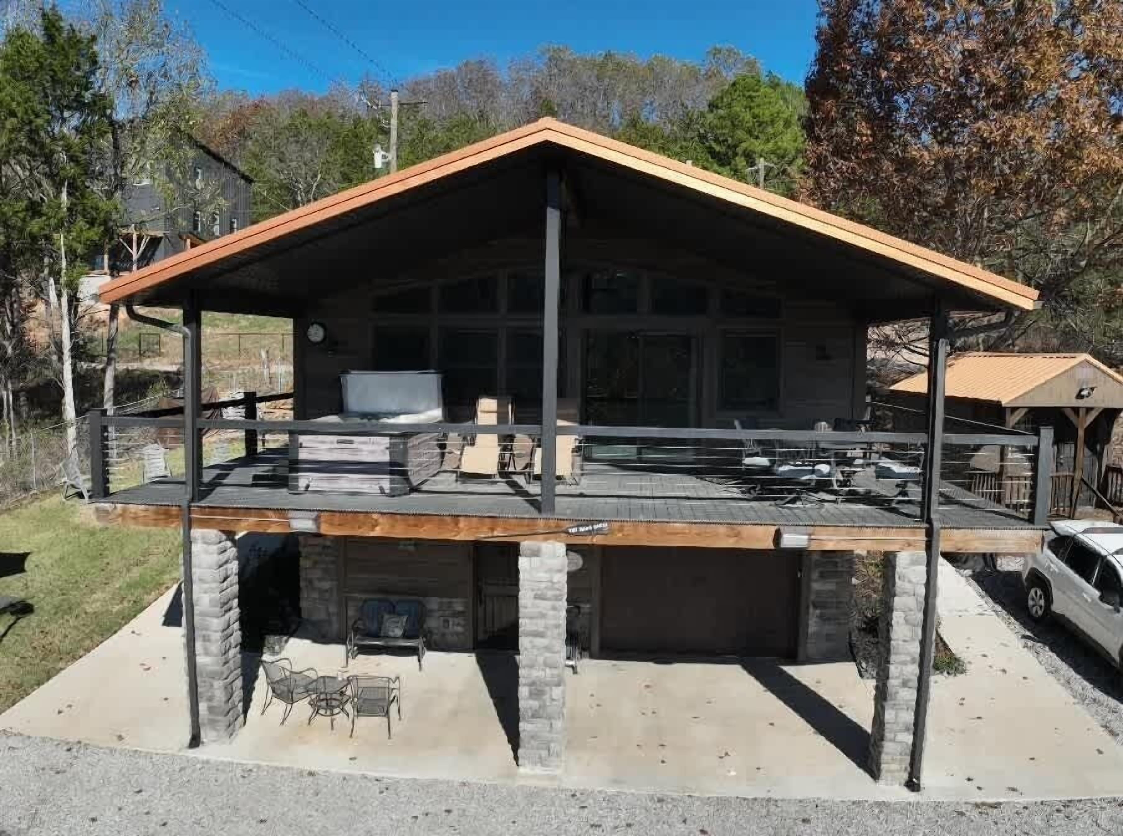 Un bâtiment à deux étages doté d’un patio couvert, d’un garage et de fondations en pierre.