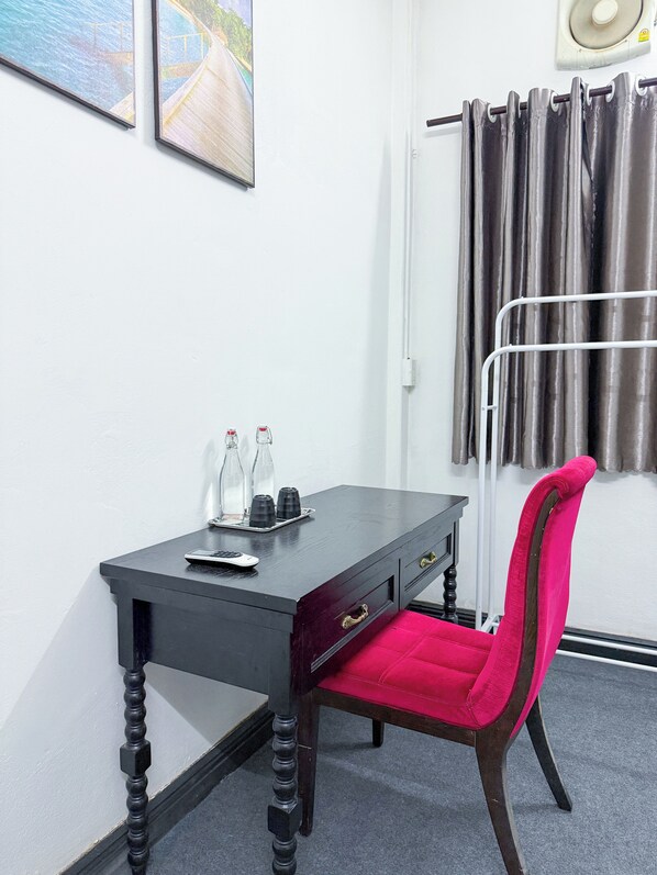 A room with a desk, a chair, a window with curtains, and a wall-mounted radiator. - Lao Home (Vientiane)
