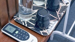 Un bagno con uno specchio, due flaconi di vetro, un contenitore nero e una bilancia digitale.