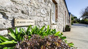 A stone building with a sign reading "Seagull Cottage."