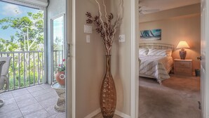 A room with a bed, a nightstand, a lamp, and a painting on the wall.