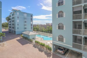Un edificio residencial de varios pisos con piscina y zona de estacionamiento.