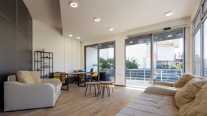 Ein modernes Wohnzimmer mit einer Couch, einem Esstisch mit Stühlen und einem Bücherregal.
