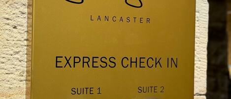 Señal de 'Secret Suites' en Lancaster que indica 'Registro Express' para la 'Suite 1' y la 'Suite 2', con lectores de tarjetas MasterCard y Visa.