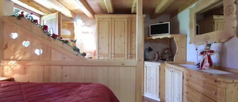 A bedroom with a wooden bed, a TV, and a dresser.