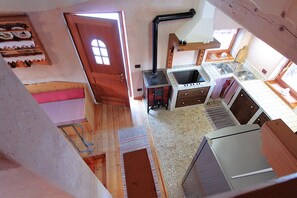 A compact kitchen with a stove, sink, and a small dining area. - Baita Mountain View Pale San Martino (Primiero San Martino di Castrozza)