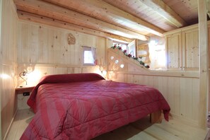A wooden room with a bed, a window, and a staircase. - Baita Mountain View Pale San Martino (Primiero San Martino di Castrozza)