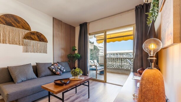 Ein modernes Wohnzimmer mit Sofa, Couchtisch und Lampe.