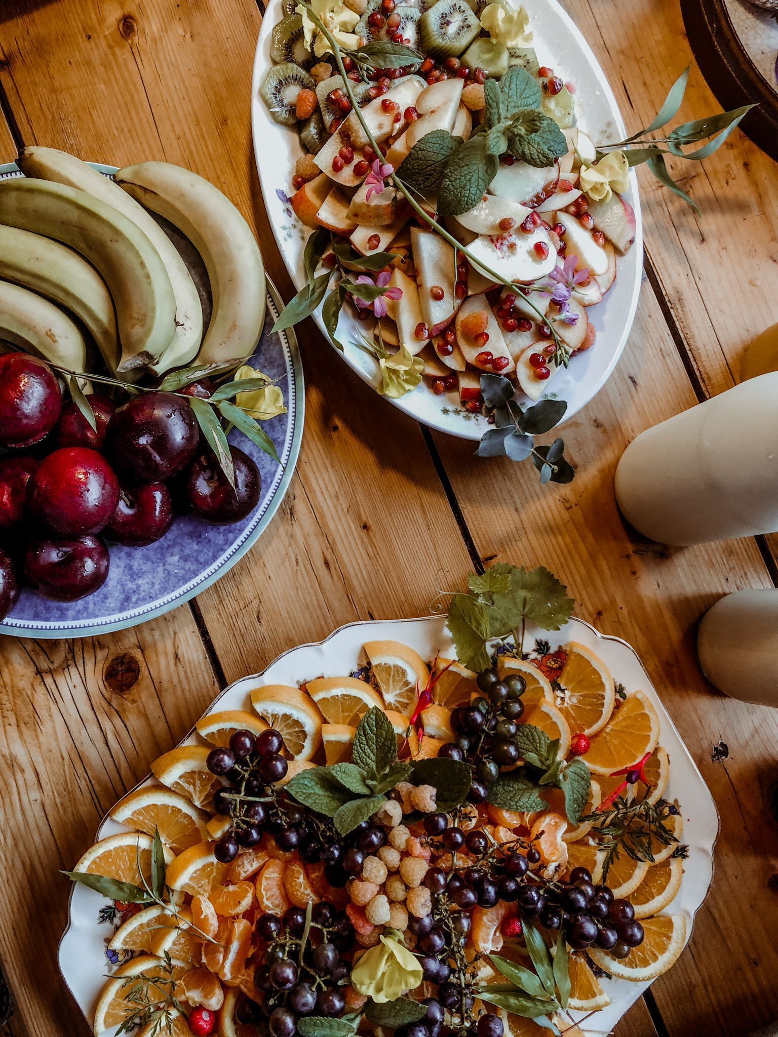 Une table en bois avec trois assiettes de fruits.