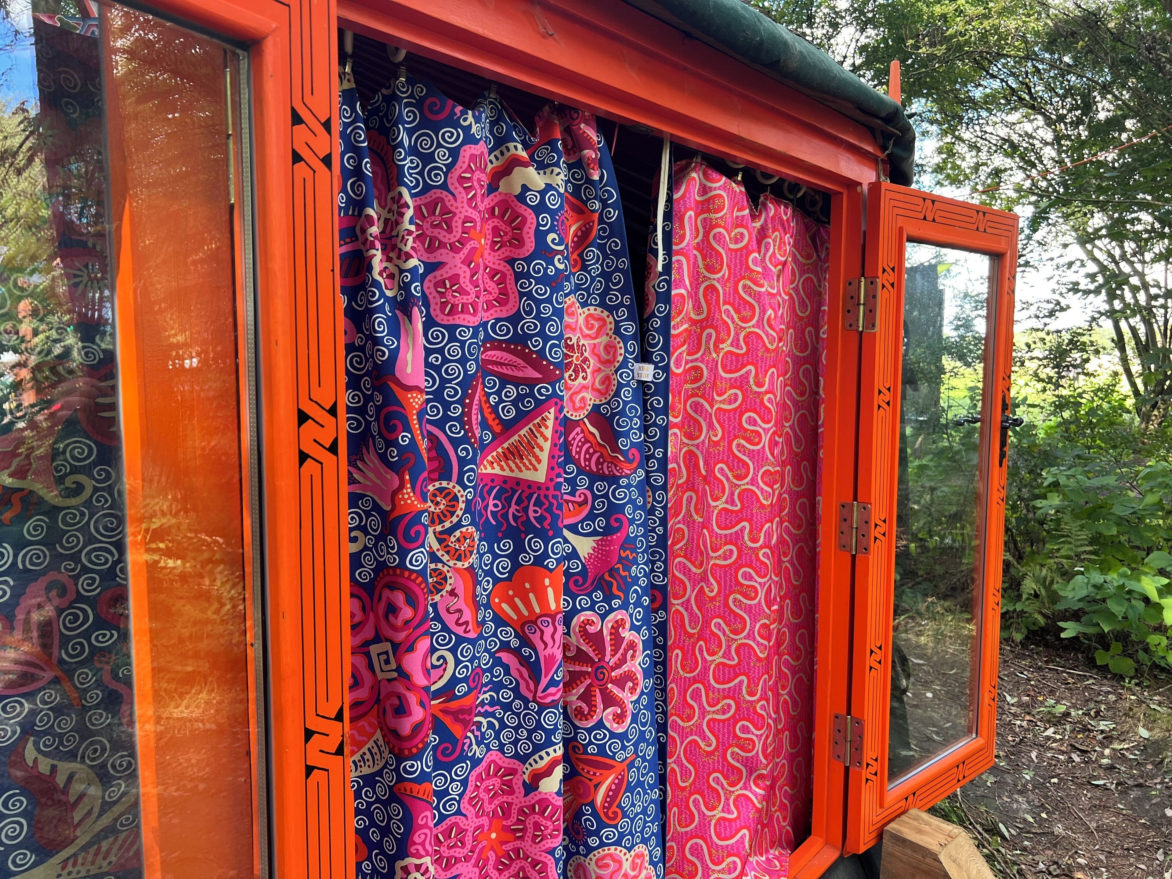 Habitació amb finestra i cortines de colors amb motius paisley.