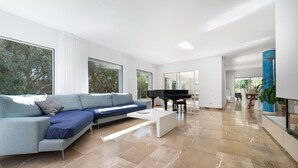 A modern living room with a sectional sofa, a piano, and a coffee table. - Son Jordi in Mallorca (Son Servera)