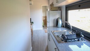 Een moderne keuken met een ingebouwde kookplaat, spoelbak en een raam met uitzicht op de omgeving.