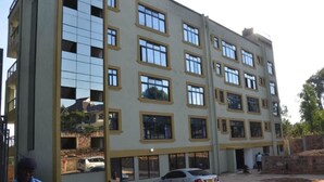 Ein mehrstöckiges Gebäude mit moderner Architektur, das eine Reihe von Fenstern und Balkonen zeigt.
