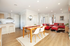 A modern apartment with a dining area, kitchen, and living space. - Northside Townhouse, Geelong (Norlane)