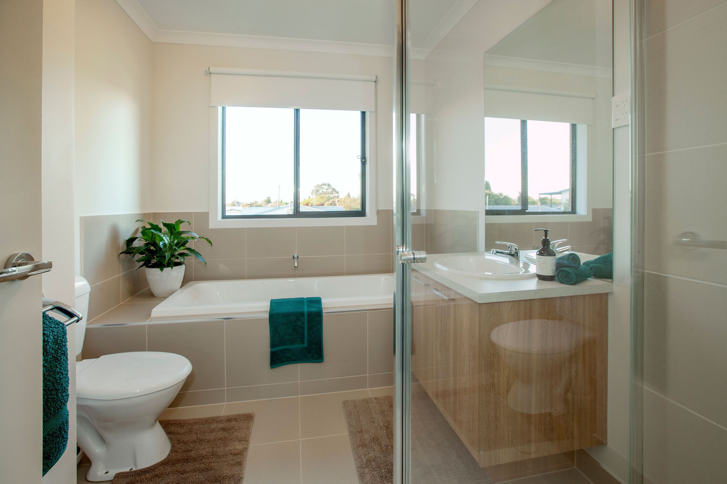 A modern bathroom with a toilet, bathtub, and sink.