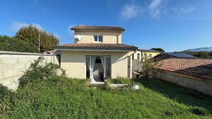 Un petit bâtiment d’un seul étage, doté d’un toit recouvert de tuiles, d’une porte bien visible et d’une petite fenêtre.