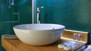 A bathroom with a large white basin, a wooden countertop, and a mirror reflecting a green wall. - Becoloured Water Lily Suite. Where it is possible to dream among the masterpieces of art. (Napoli)