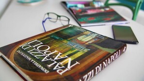 A book titled 'Piazza Napolitana' on a table with a smartphone and a pair of glasses. - Becoloured Water Lily Suite. Where it is possible to dream among the masterpieces of art. (Napoli)